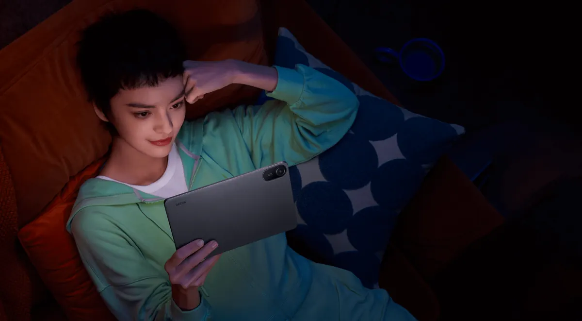 Pessoa assistindo conteúdo no Redmi Pad 2 em ambiente escuro